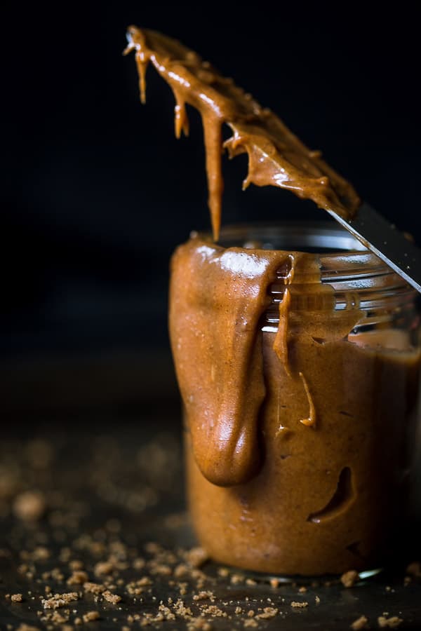 Cookie butter spread dripping down the side of a glass jar.