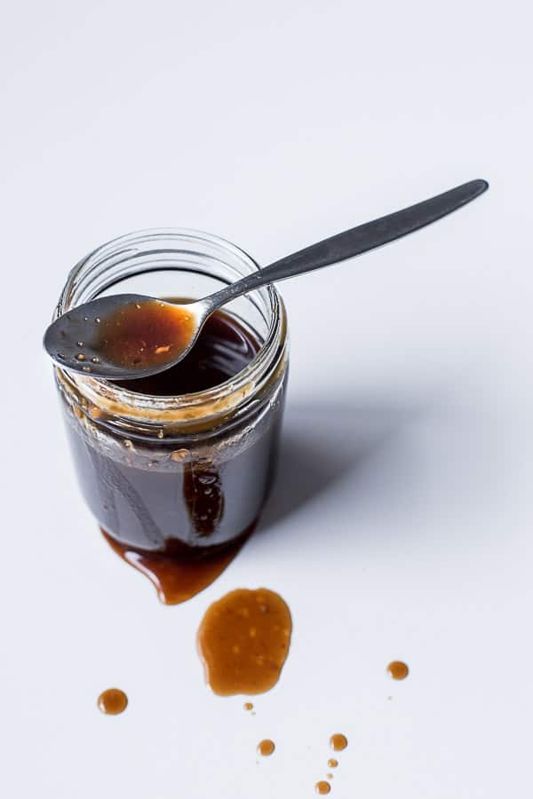 Jar of sauce with the spoon resting across the top.
