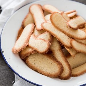 Pile of crispy, thin Italian biscuits in white bowl.