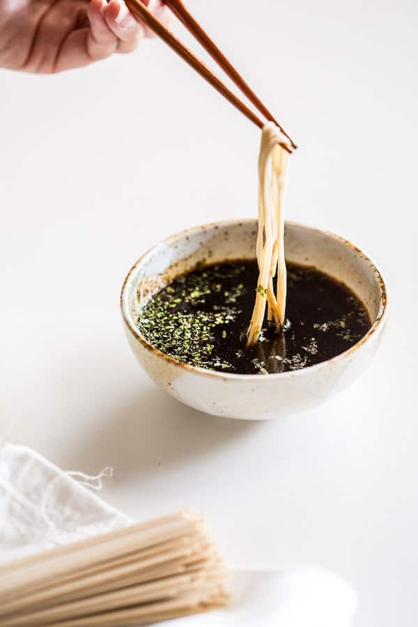 Dipping cold noodles into soba sauce.