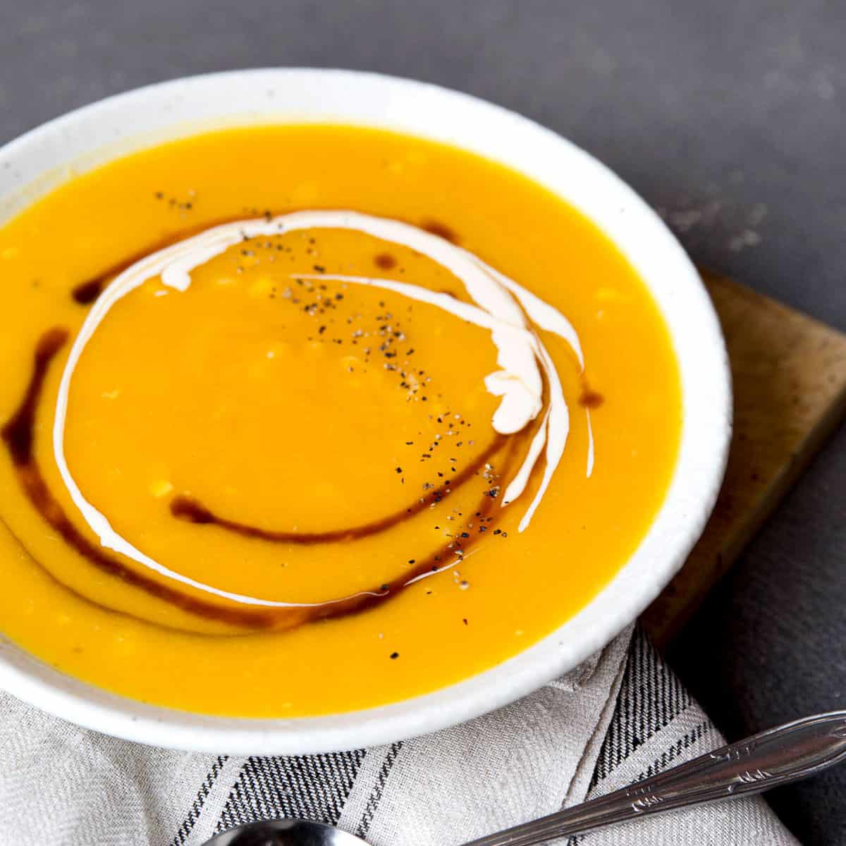 Large bowl of pumpkin soup with swirls.