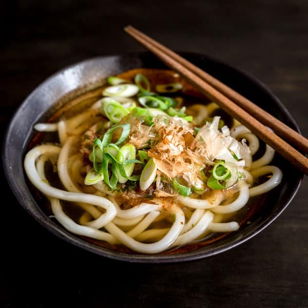 Udon noodle soup in a bowl of udon soup stock made with dashi, soy sauce and mirin.