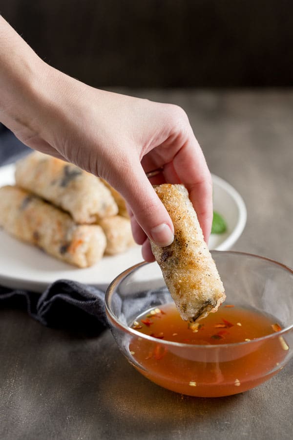 Dipping a crispy Vietnamese fried spring roll into spicy homemade dipping sauce.