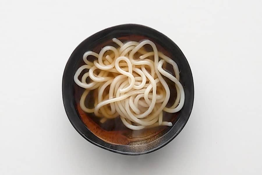 Udon noodles floating in udon noodle soup base.