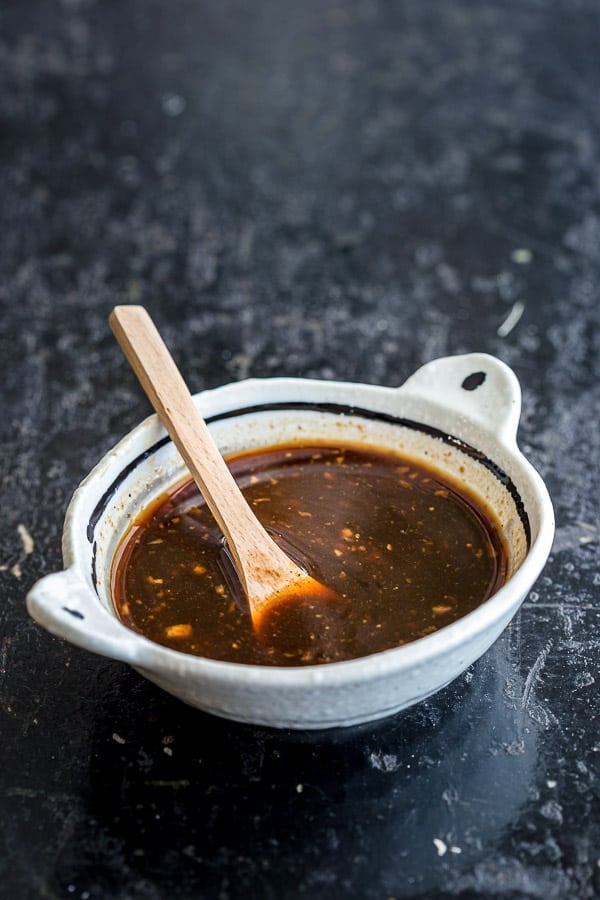 Bowl of homemade Takoyaki Sauce in white bowl with spoon.