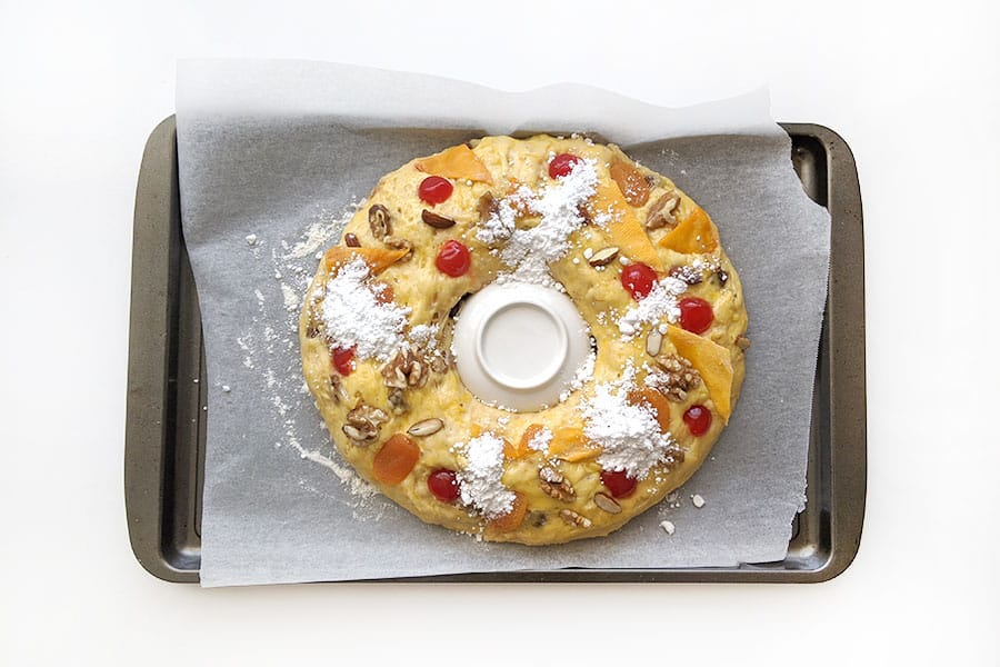 Bolo Rei with fruit and nuts placed on top ready to bake in the oven.