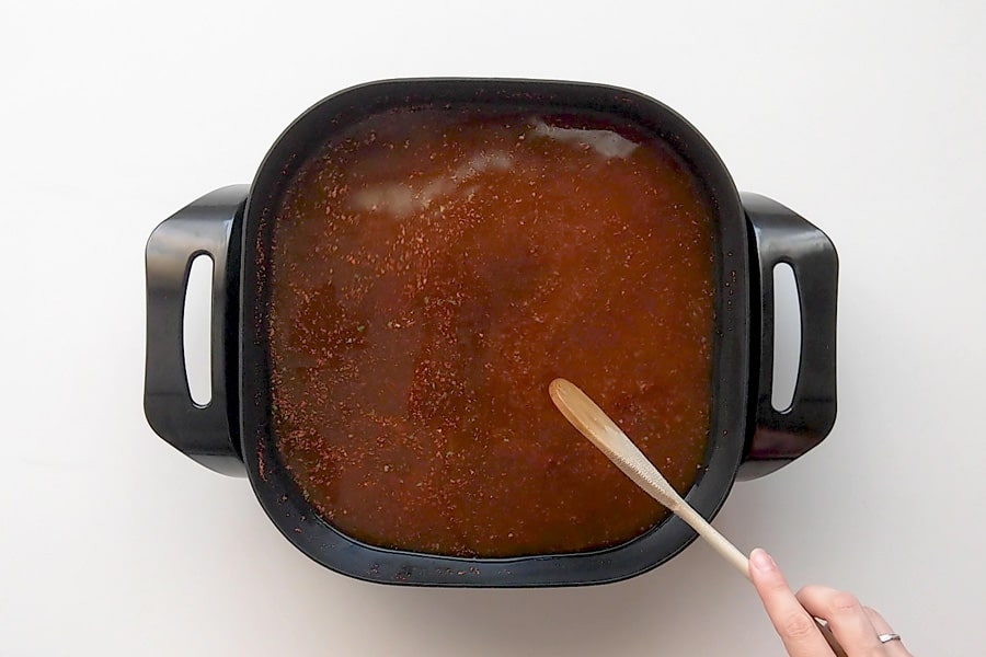 Bringing gochujang broth to the boil in a medium sized electric frypan.