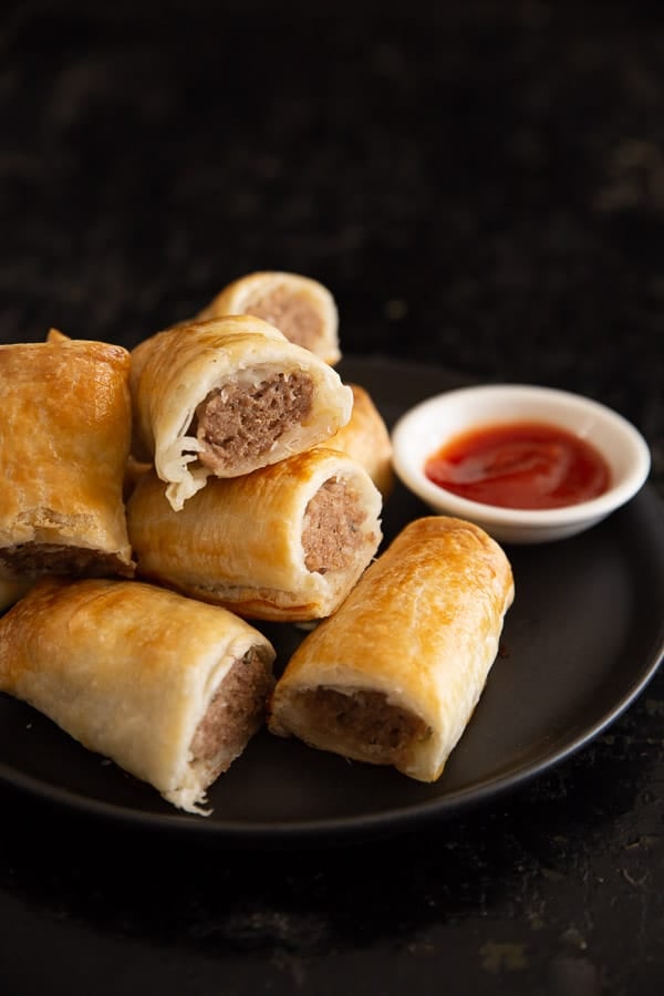 Close up of sausage rolls with tomato sauce.