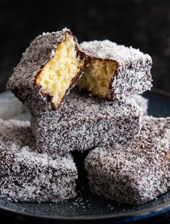 A stack of homemade lamingtons on a plate.