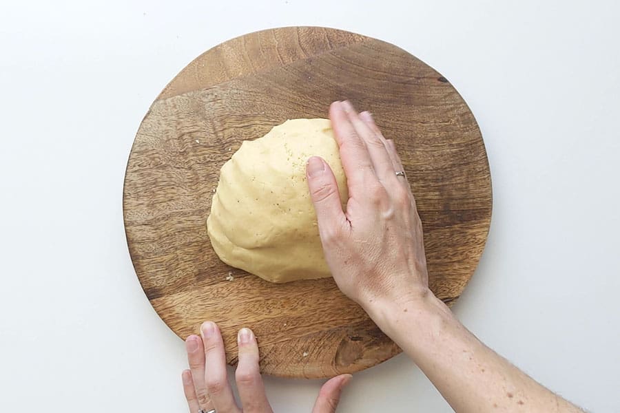 Koulourakia dough on a chopping board.