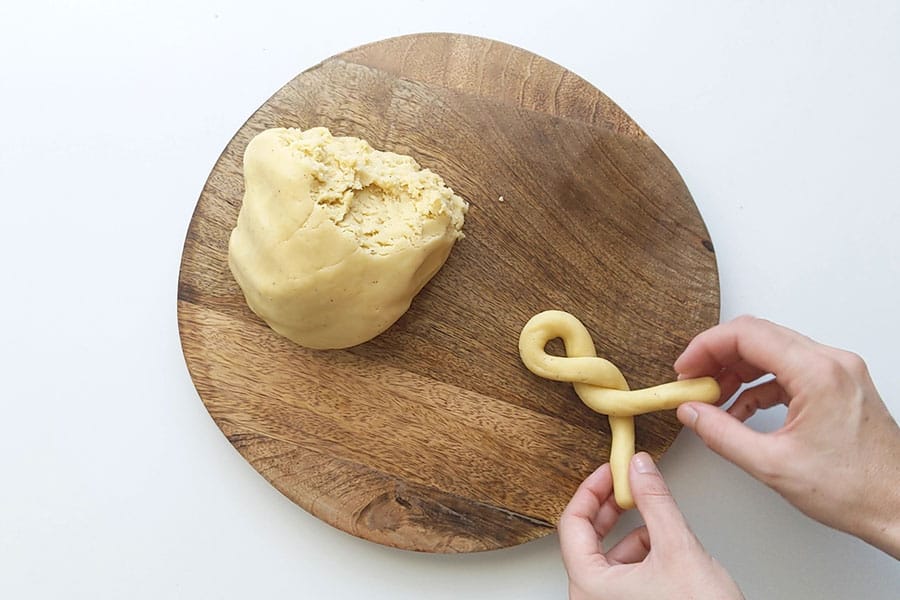 Koulourakia being tied into a twist shape cookie.