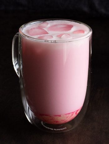 Glass of Thai pink milk on dark background.