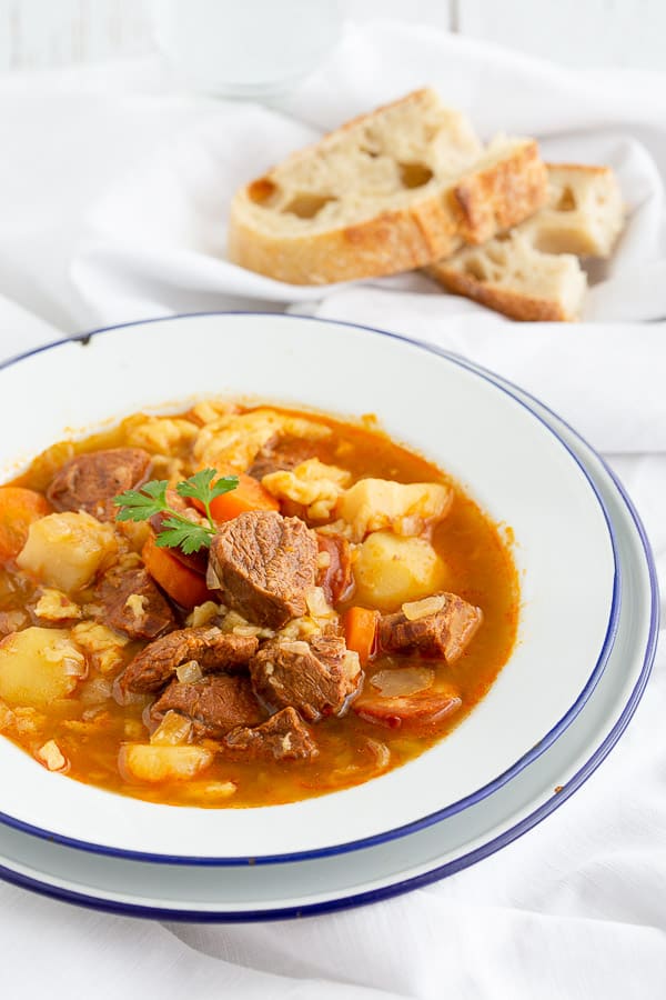 Bowl of hot goulash with crusty bread.
