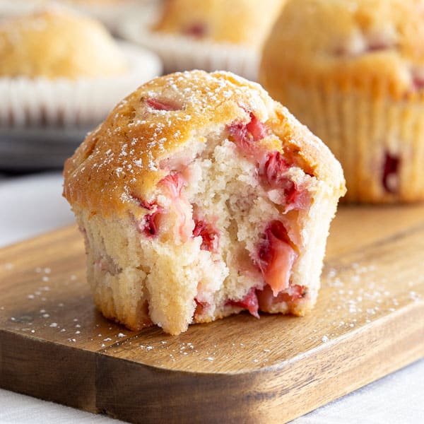 Strawberry muffin with bite to show the inside.