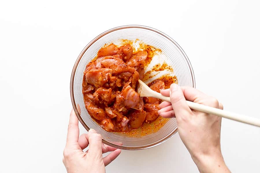 Mixing the chicken in with the spicy Dakgalbi sauce marinade.