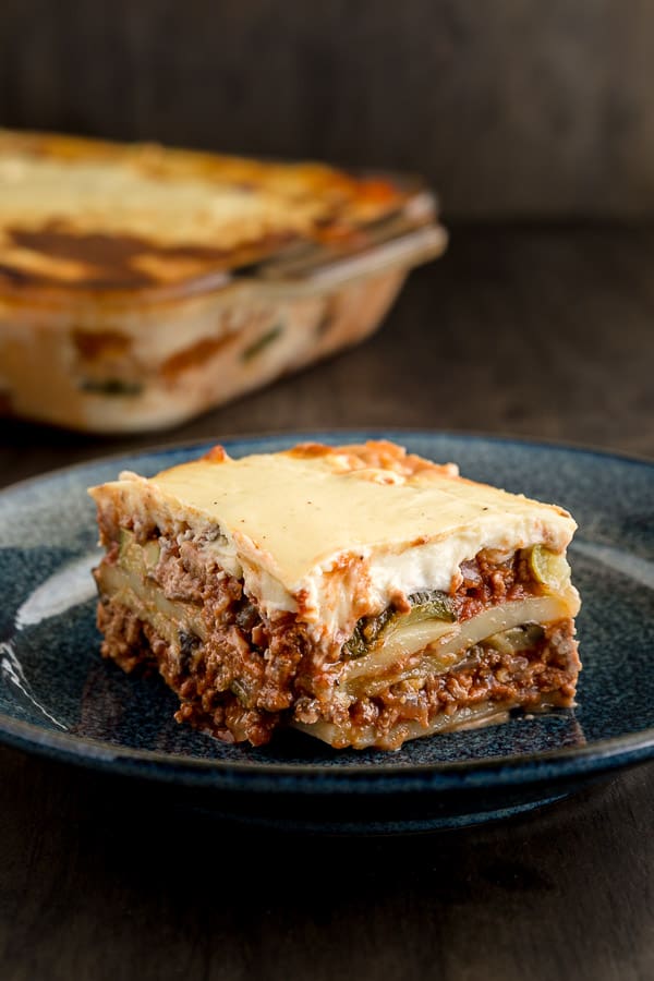 A slice of moussaka on a plate showing the veggie and meat layers.