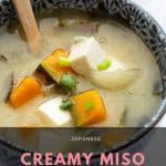 Bowl of chunky miso soup with a spoon.