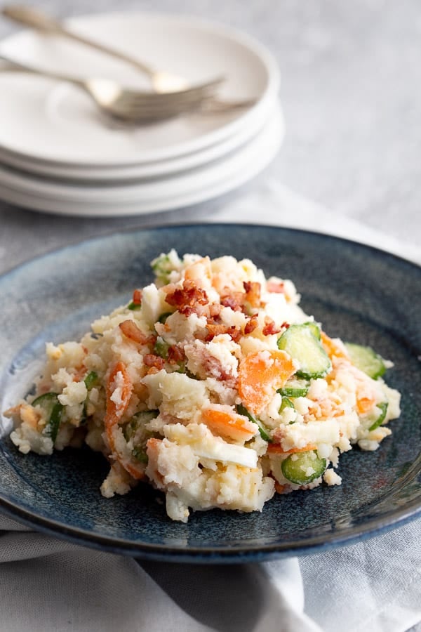 Fresh bowl of creamy Japanese potato salad topped with bacon pieces.