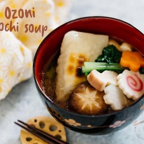 A bowl of ozoni mochi miso soup next to a set of chopsticks.