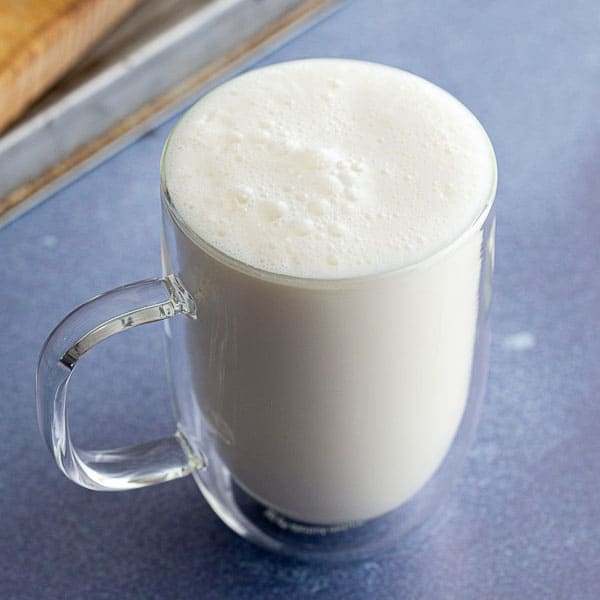Glass filled with frothy yoghurt drink.