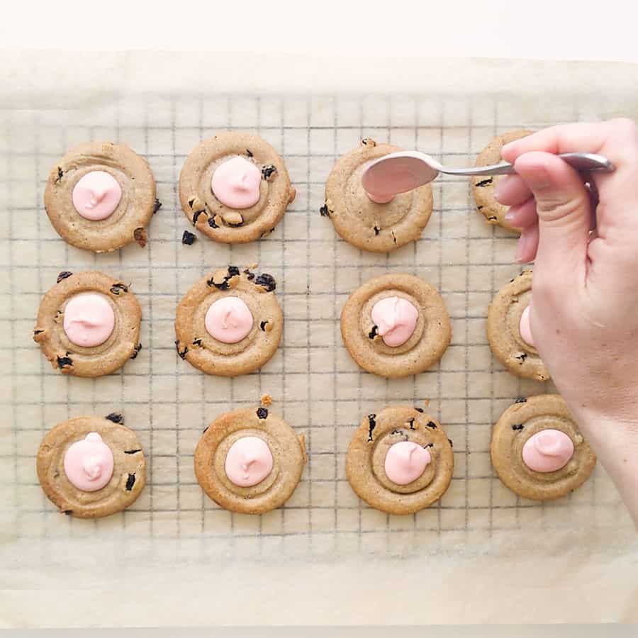 Topping coffee scroll biscuits with pink chocolate icing.
