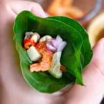 A betel leaf cone with dried shrimp, kaffir lime and other fresh Thai ingredients.