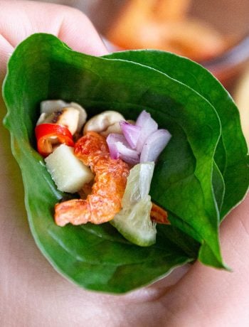 A betel leaf cone with dried shrimp, kaffir lime and other fresh Thai ingredients.