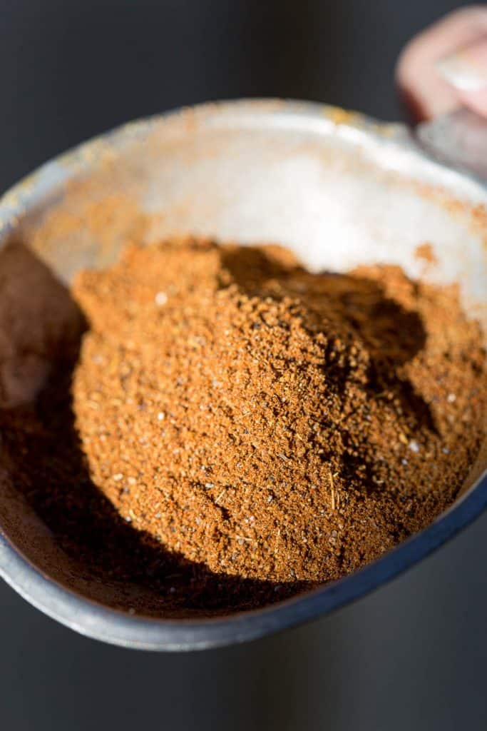 Brown spice mix known as Baharat in small container.