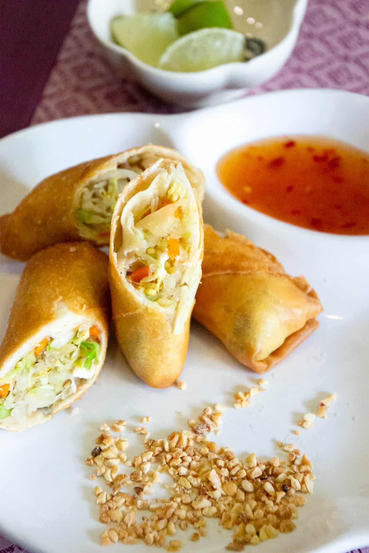 Thai spring rolls sliced in half with lime and sweet chilli sauce.
