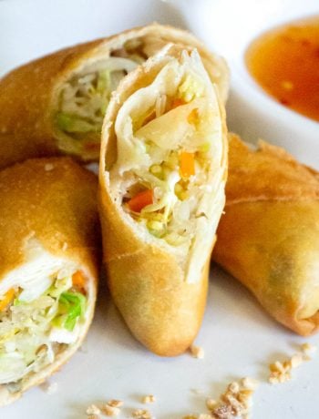 Close up of fried spring rolls on a plate with sweet chilli dipping sauce.