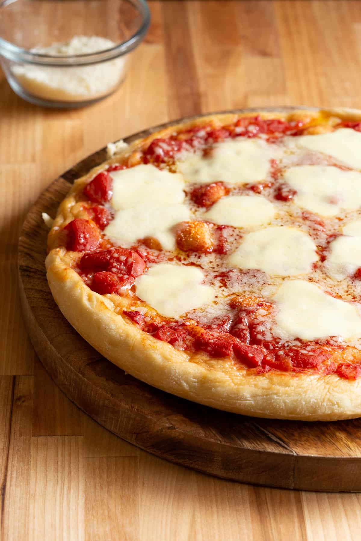 Large Naples style pizza topped with tomato and mozzarella.