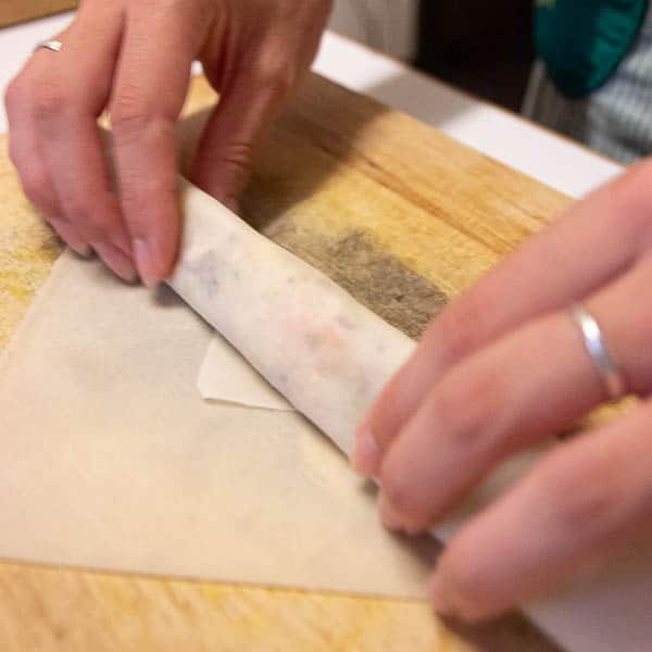 Rolling the spring roll pastry and filling.