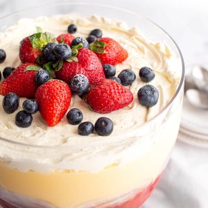 Strawberries and blueberries topped on a custard trifle.