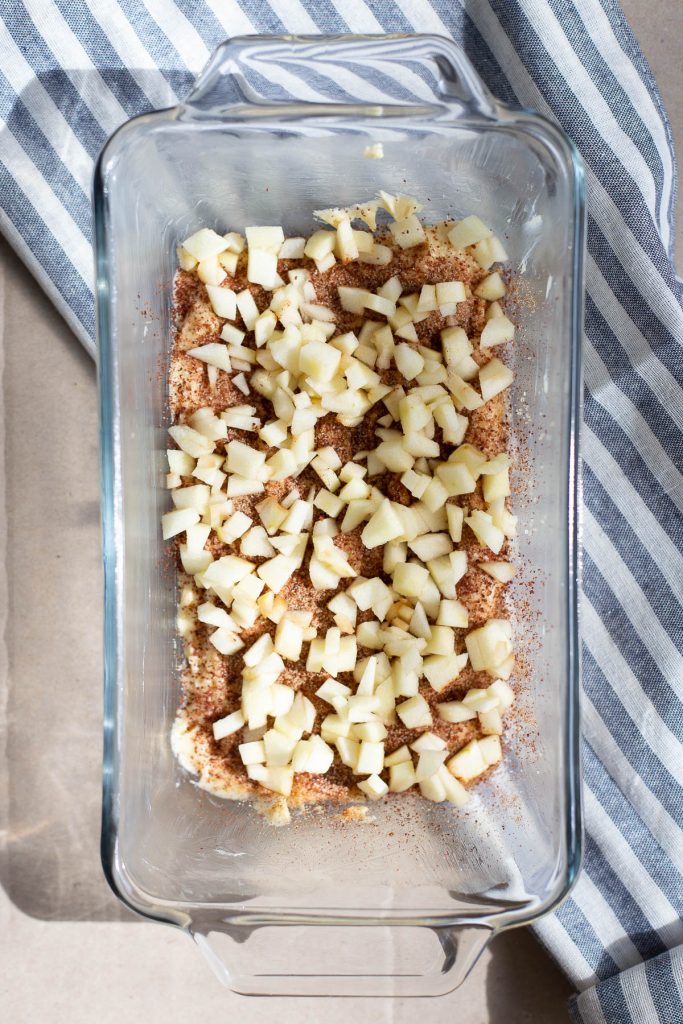 The first layer of cake batter topped with cinnamon sugar, sumac and chopped apples.