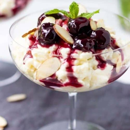 Glass filled with danish rice pudding and cherry syrup.