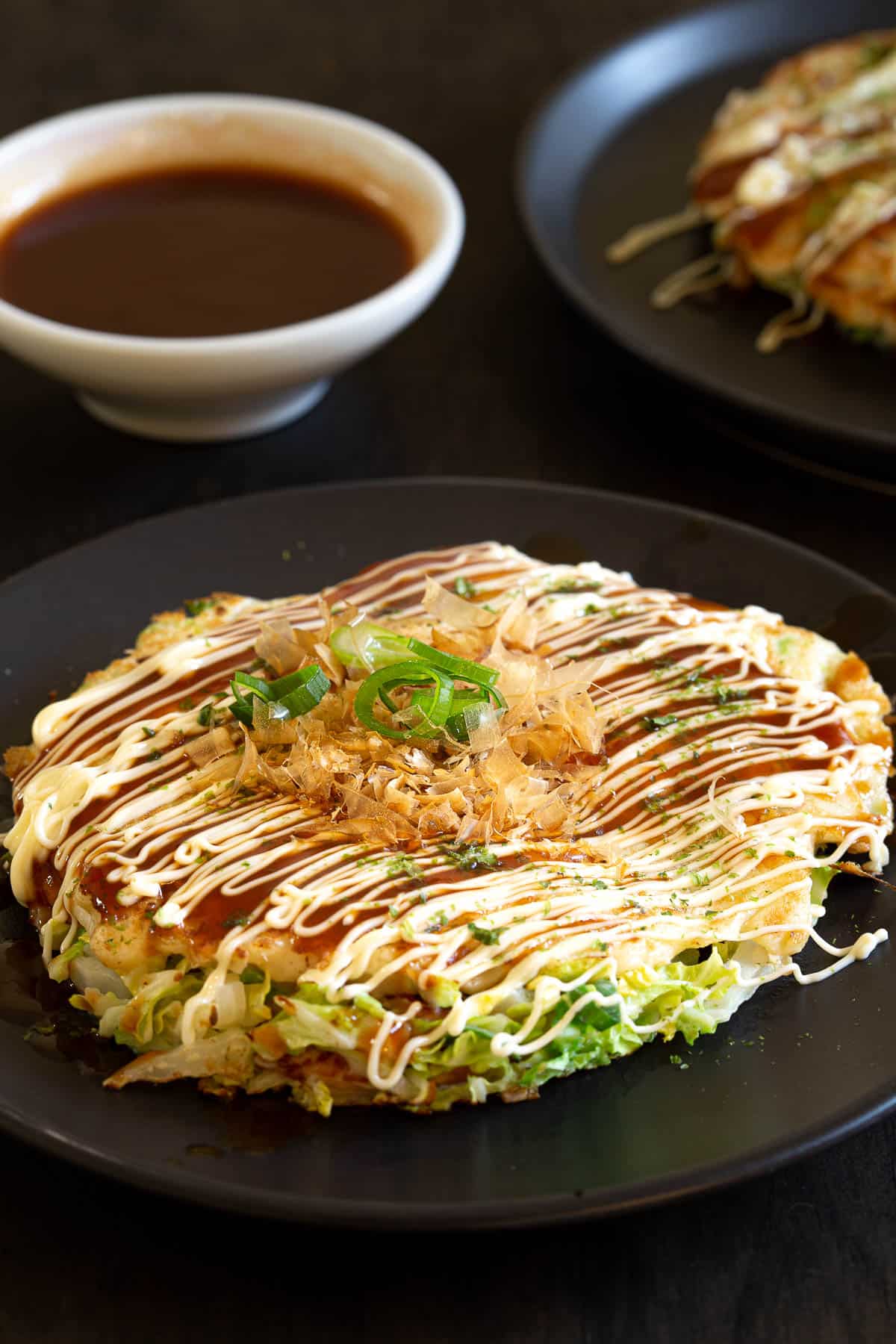 Japanese okonomiyaki pancake with katsuoboshi and aonori on top.