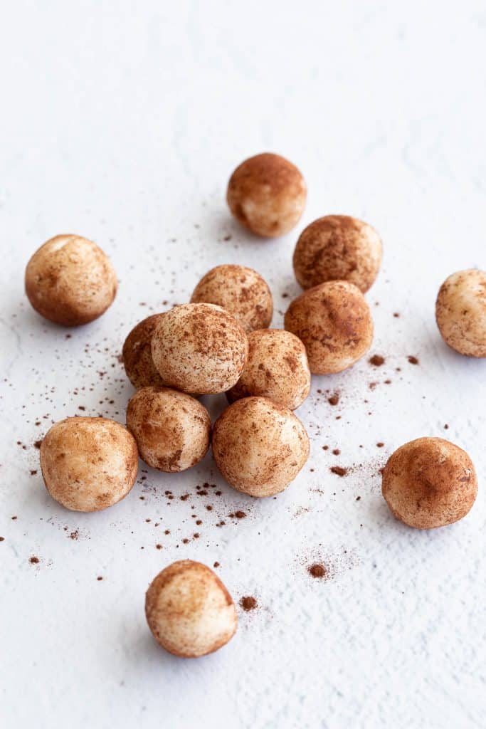 Coconut balls coated in cocoa on a white background.