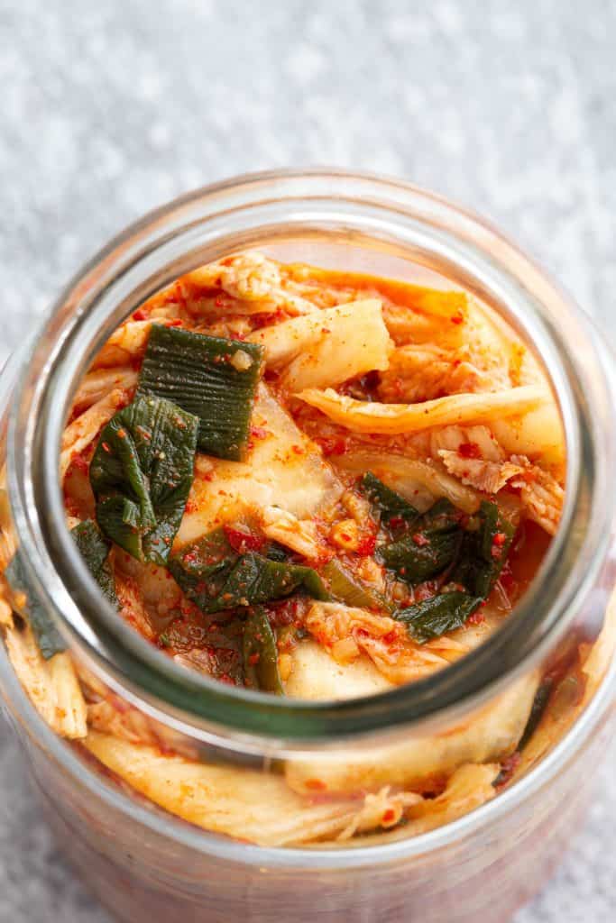 Tightly packed strips of fermented napa cabbage in a jar.