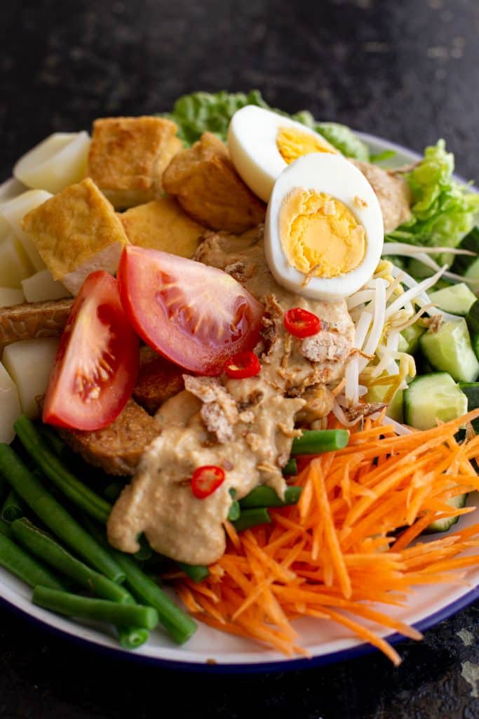 Gado gado salad topped with spicy peanut sauce and chopped chilli.