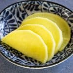 Slices of fresh yellow pickled daikon.