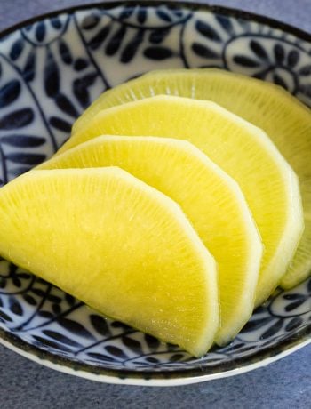 Slices of fresh yellow pickled daikon.