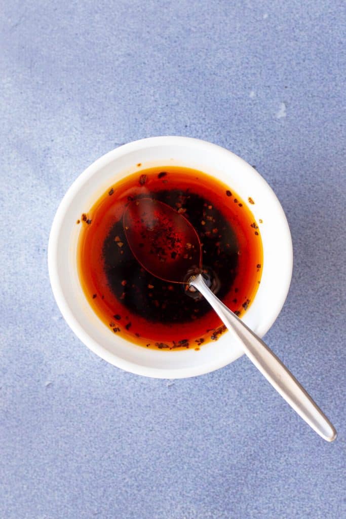 Small dish of rayu chilli oil with spoon.