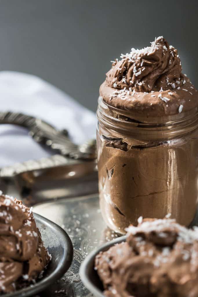 A glass jar filled with fresh chocolate mousse.