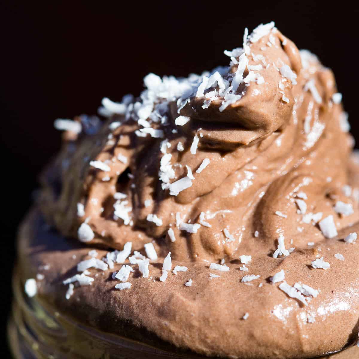 Close up shot of fluffy chocolate mousse garnished with desiccated coconut.