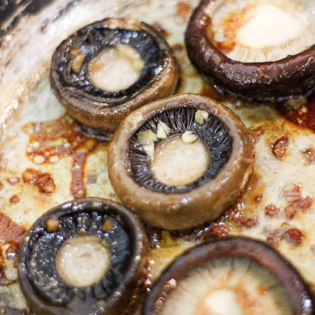Slow cooked mushrooms cooking in a saucepan.