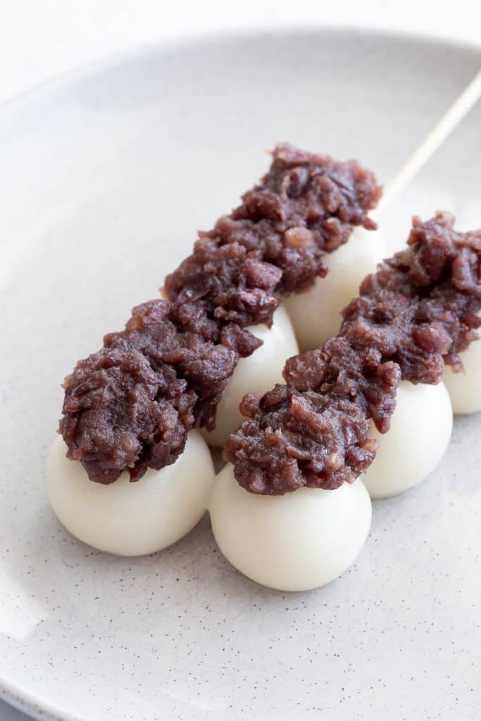 Two sticks with dango topped with sweet red bean paste.
