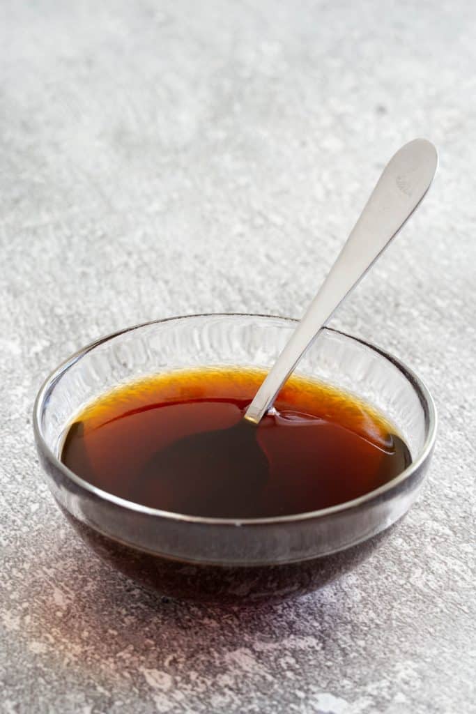 Teriyaki sauce in a glass bowl with a spoon.