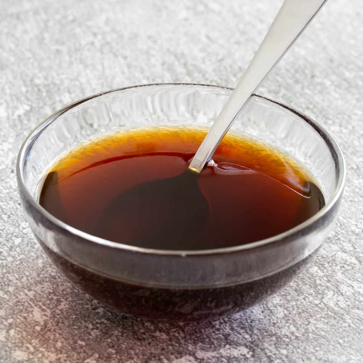 Bowl of homemade teriyaki sauce with spoon in it.