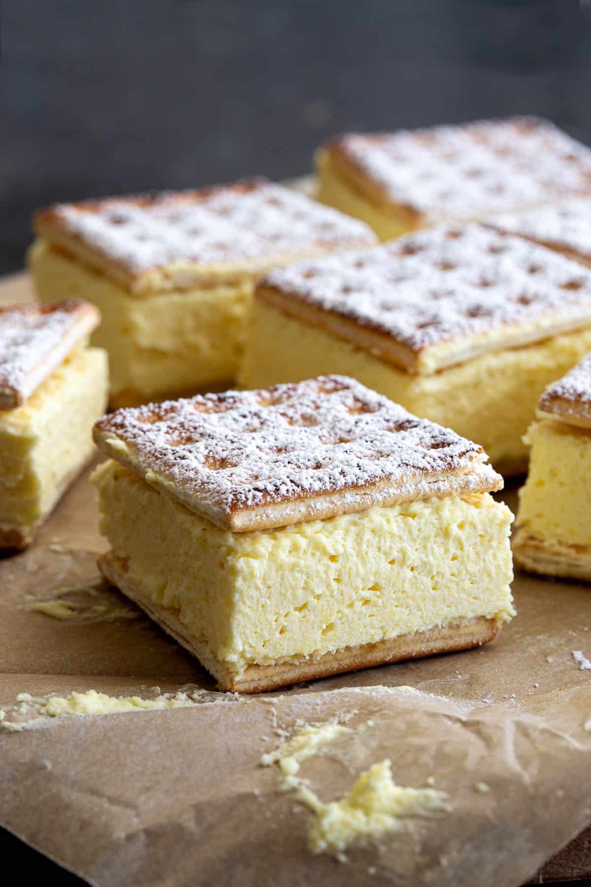 Close up view of a vanilla slice showing the creamy centre and icing sugar on top.