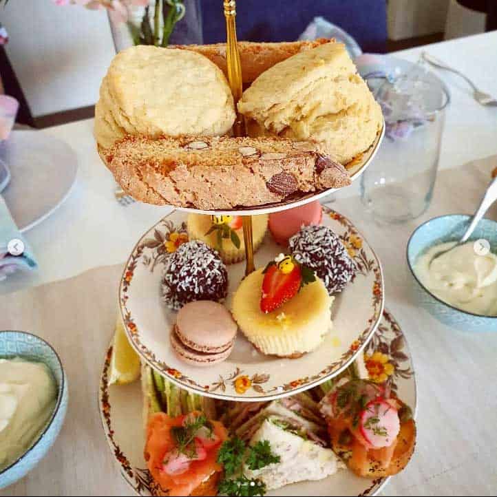 A three tier high tea stand filled with delicacies including cantucci biscuits.